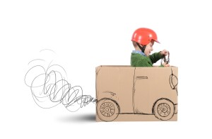 Creative baby plays with his cardboard car