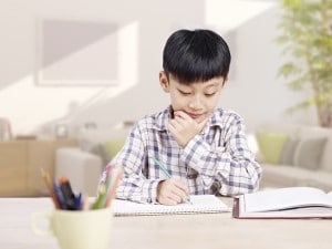 10 year-old asian elementary schoolboy doing homework at home.