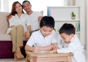 Asian parent looking at their kids doing homework