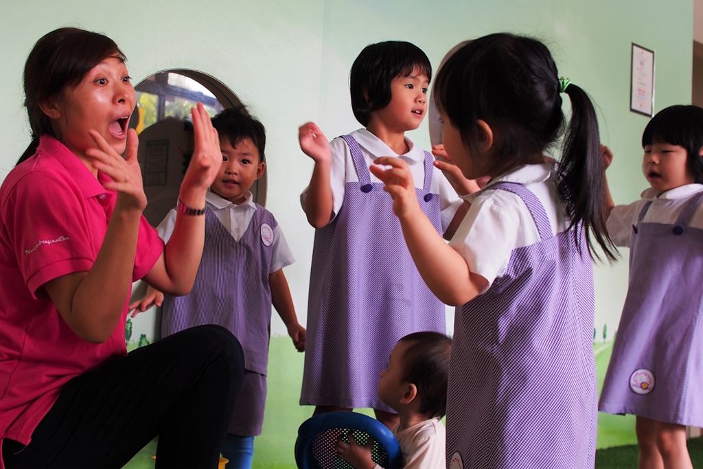 preschool teacher singing with children